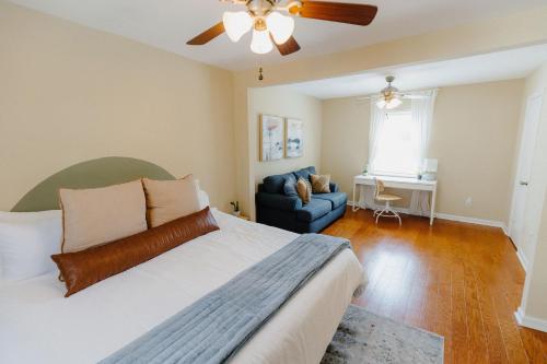 a bedroom with a bed and a couch and a ceiling fan at Centrally Located 3BR Overton Square Fast WiFi Free Parking Yes Pets in Memphis