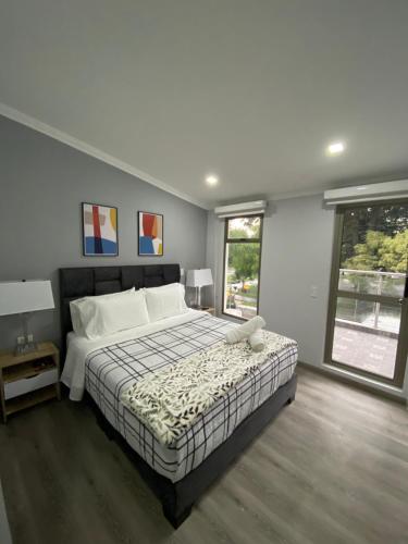 Un dormitorio con una cama grande y una ventana en Cal Bed & Breakfast, en Bogotá