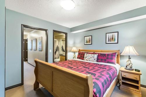 a bedroom with a bed with a purple bedspread at Mystic Getaway in Canmore