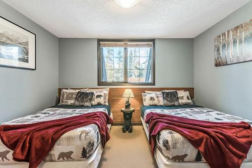 a bedroom with two beds and a window at Mystic Getaway in Canmore