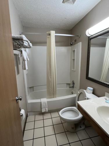 a bathroom with a tub and a toilet and a sink at Raceway inn in Martinsville