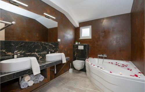ein Badezimmer mit einer Badewanne, einem Waschbecken und einem WC in der Unterkunft Stunning Home In Grubine With Heated Swimming Pool in Grubine
