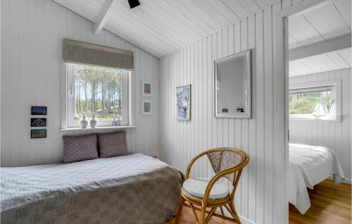 a bedroom with a bed and a chair and a window at Stunning Home In Thisted With 3 Bedrooms in Sønder Vorupør