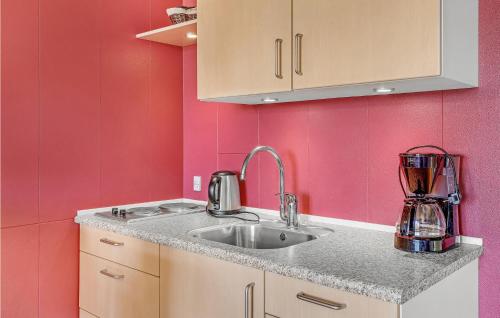 a kitchen with a sink and pink walls at Stunning Apartment In Allinge With Wifi in Allinge