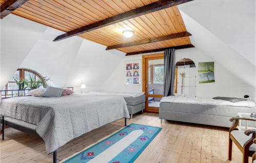sypialnia z 2 łóżkami i niebieskim dywanem w obiekcie Mormors Hus w mieście Mariager