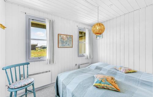 BjerregårdにあるStunning Home In Hvide Sande With Saunaのベッドルーム1室(ベッド1台、椅子、窓付)