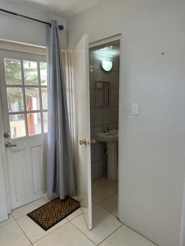 a bathroom with a toilet and a sink and a door at Studio - begane grond - poolside in Kralendijk