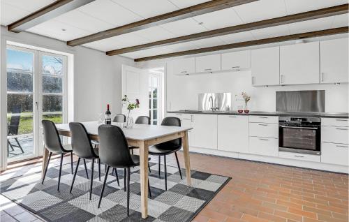 レネにあるGorgeous Apartment In Rønne With Wifiの白いキッチン(テーブル、椅子付)