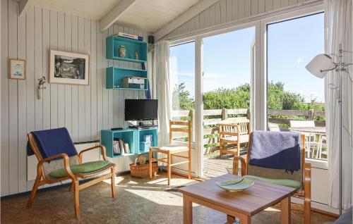 a living room with chairs and a table and a television at Hus 18 in Allinge