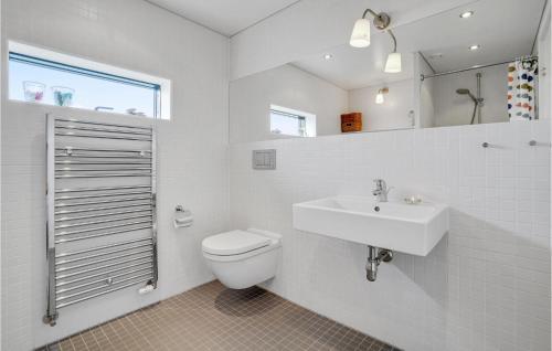 La salle de bains blanche est pourvue de toilettes et d'un lavabo. dans l'établissement Stunning Home In Ulfborg With 2 Bedrooms And Wifi, à Thorsminde