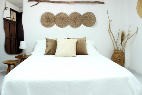 ein Schlafzimmer mit einem weißen Bett mit Kissen in der Unterkunft Playa Centro Apartamento Equipado in Santa Marta