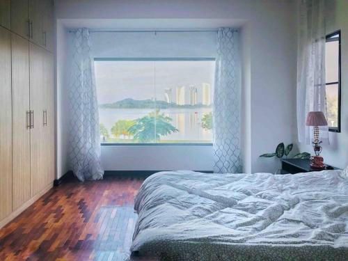 um quarto com uma cama e uma grande janela em Romantic Suite by the Lake em Cyberjaya