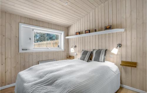 a bedroom with a white bed and a window at Amazing Home In Nexø With Sauna in Neksø