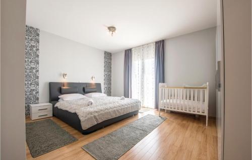 a bedroom with a bed and a baby crib at Cozy Home In Solin With House A Panoramic View in Solin