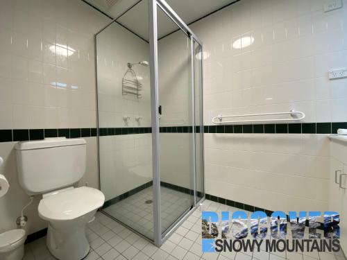 a bathroom with a toilet and a glass shower at Milkwood in Thredbo