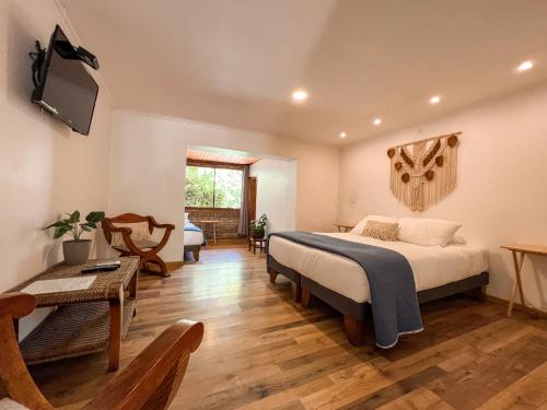 Barros Wellness & Spa Resort Boutique في Calle Larga: غرفة نوم مع سرير وغرفة معيشة