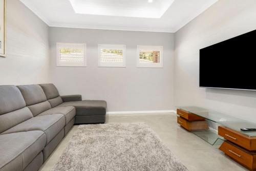 a living room with a couch and a flat screen tv at Tranquil Retreat Busselton in Geographe