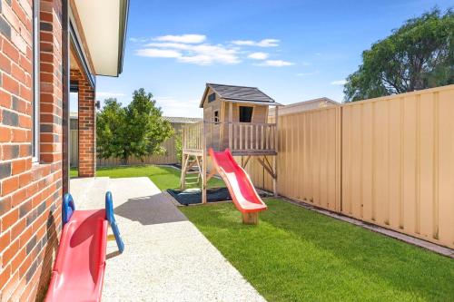 a backyard with a playground with a wooden fence at Tranquil Retreat Busselton in Geographe