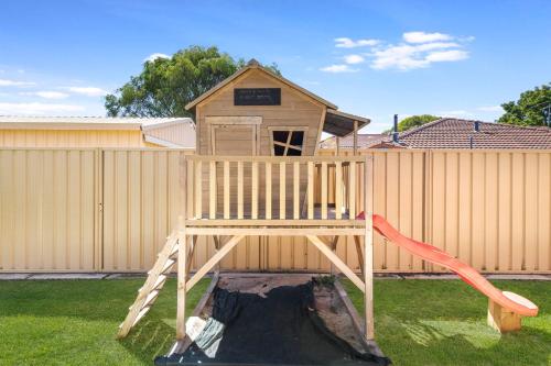 a wooden playset in a yard with a house at Tranquil Retreat Busselton in Geographe