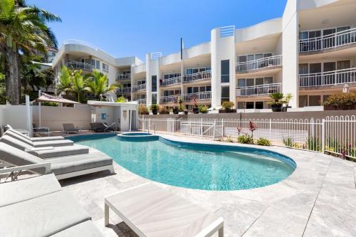 a swimming pool in front of a building at Kirra Palms Holiday Apartments in Gold Coast