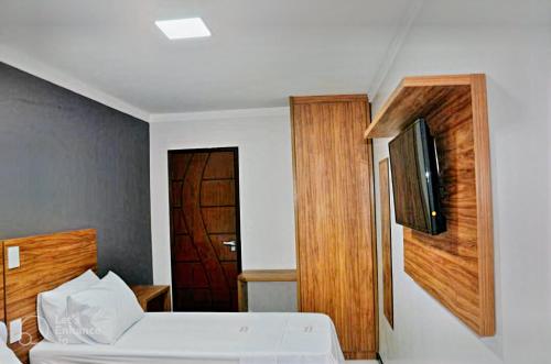 una camera con letto e TV a parete di Hotel Center a Feira de Santana