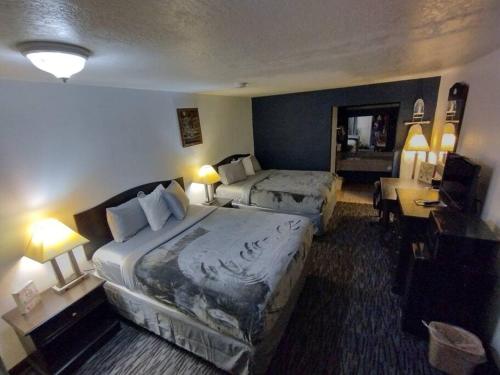 a hotel room with two beds and a desk at OSU 2 Queen Beds Hotel Room 221 Wi-Fi Hot Tub Booking in Stillwater