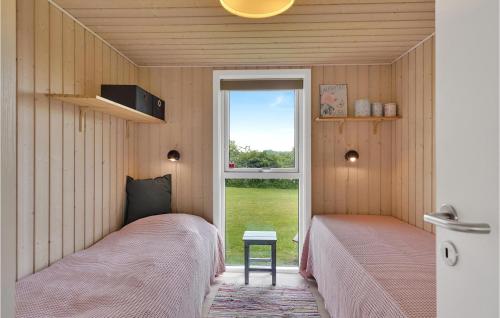 2 Betten in einem kleinen Zimmer mit Fenster in der Unterkunft 3 Bedroom Nice Home In Faaborg in Fåborg
