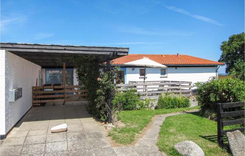 a white house with an umbrella in a yard at 2 Bedroom Stunning Apartment In Allinge in Allinge