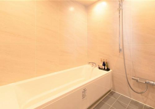 a white bath tub in a bathroom with a shower at Tokyu Stay Sapporo Odori in Sapporo