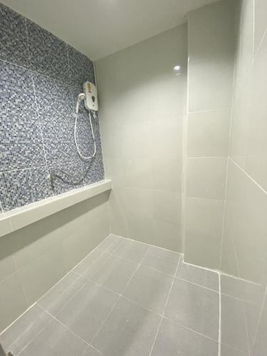 baño blanco con ducha y teléfono en บ้านสายสิริ, en Ban Bang Talat