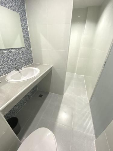 a white bathroom with a sink and a toilet at บ้านสายสิริ in Ban Bang Talat