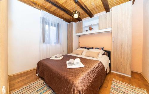 a bedroom with a bed with two white shoes on it at Beautiful Home In Drvenik Veliki With 2 Bedrooms, Wifi And Outdoor Swimming Pool in Drvenik Veli