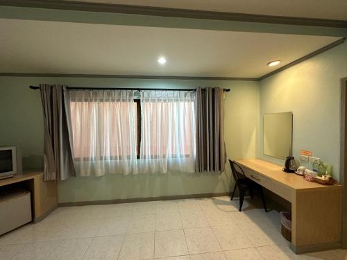 a room with a desk and a window at Thipurai City Hotel in Hua Hin