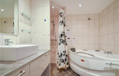 a bathroom with a sink and a tub next to a toilet at Awesome Home In Rm With 3 Bedrooms And Wifi in Bolilmark