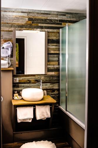une salle de bain avec un lavabo et un miroir dans l'établissement Logis Le Cheval Rouge, à Sainte-Menehould
