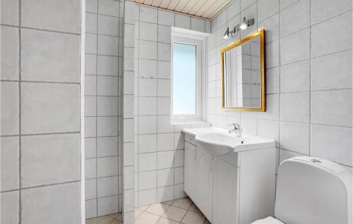a white bathroom with a sink and a mirror at Cozy Home In Rm With Kitchen in Tagholm