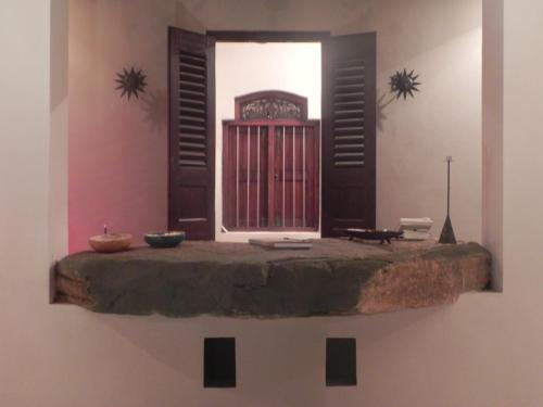 a room with a wall with a window and a table at Amanda Beach Villas in Unawatuna