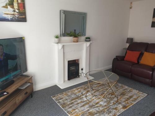 a living room with a couch and a fireplace at Accomodation for contractors & professionals 3 bed house with parking in Lighthorne