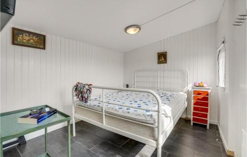 a small bedroom with a white bed and a table at 1 Bedroom Beautiful Home In Bandholm in Bandholm