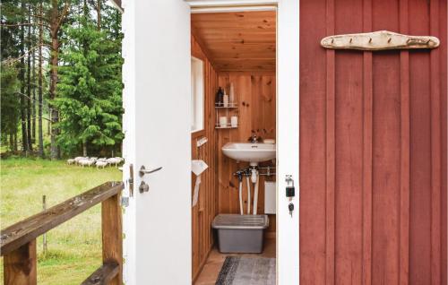baño con lavabo junto a un granero rojo en 2 Bedroom Nice Home In Nssj, en Nässjö