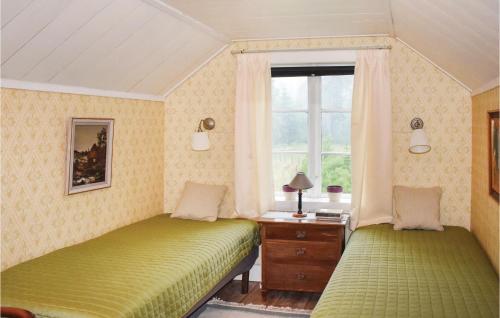 two beds in a room with a window at Two-Bedroom Holiday Home In Nassjo in Nässjö