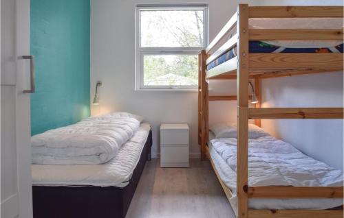 a bedroom with two bunk beds and a window at 3 Bedroom Nice Home In Tranekr in Lohals