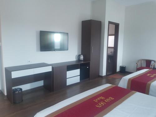 een slaapkamer met 2 bedden en een bureau met een televisie bij Khách sạn Bảo Sơn Bắc Giang in Làng Thành