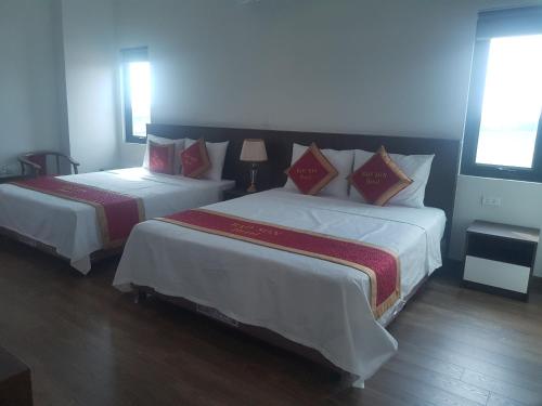 a bedroom with two beds with red and white sheets at Khách sạn Bảo Sơn Bắc Giang in Làng Thành