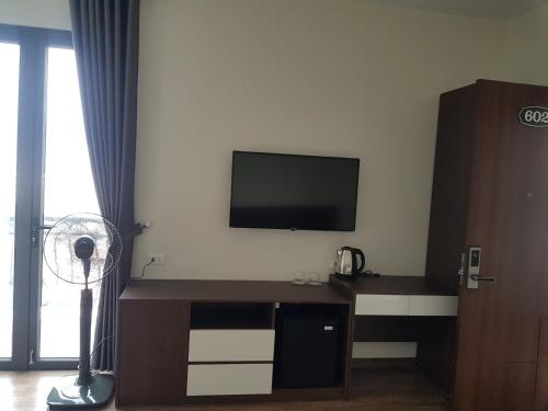 een kamer met een tv en een bureau met een ventilator bij Khách sạn Bảo Sơn Bắc Giang in Làng Thành