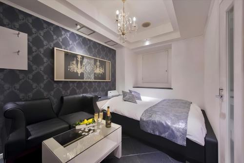 een hotelkamer met een bed en een bank bij HOTEL REFRAIN in Tokyo