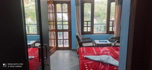 a room with two beds and a room with windows at Mountain and Moon, Dharamkot in Dharamshala
