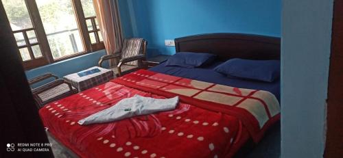 a bedroom with a bed with a red and white blanket at Mountain and Moon, Dharamkot in Dharamshala