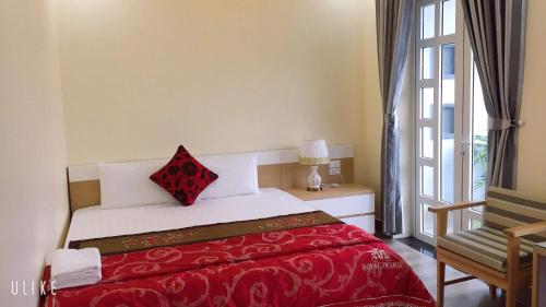 a bedroom with a bed with a red blanket at Cat Ba Central Homestay in Cat Ba