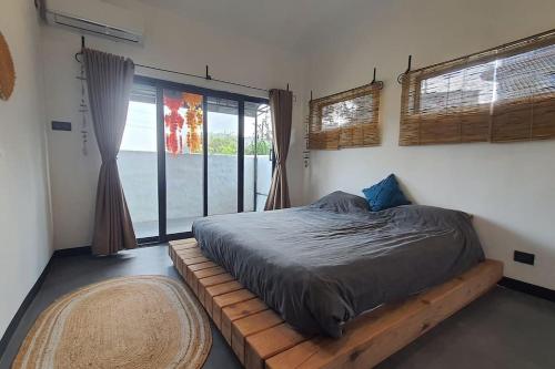 a bed in a room with a large window at Bali Villa Pokhara in Pokhara